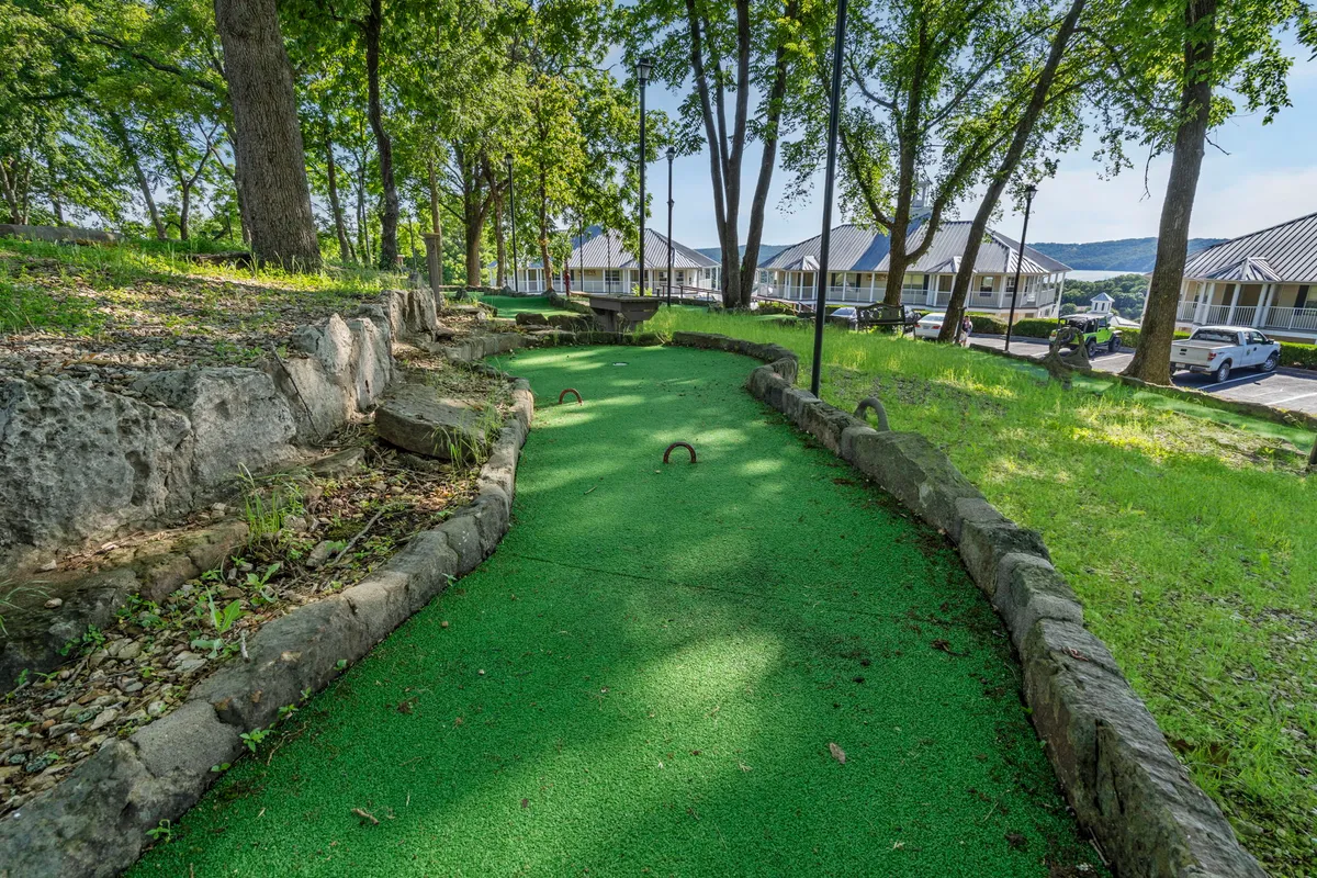 This image highlights the resort's mini-golf course, surrounded by lush greenery and natural stone borders. The playful area is designed for families and friends to enjoy friendly competition, creating the perfect environment for lighthearted outdoor activities.