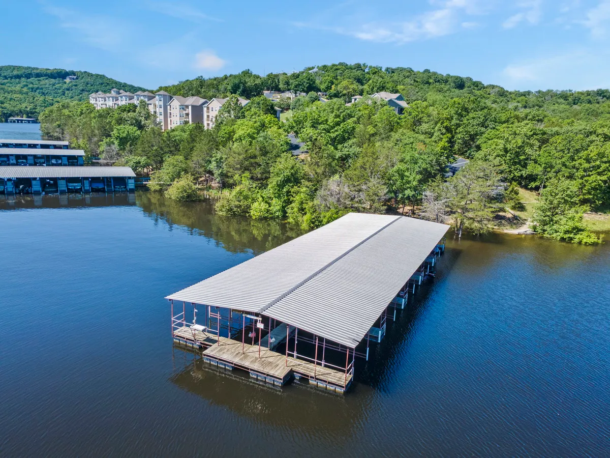 A peaceful view of the boat dock framed by surrounding greenery and calm waters, ideal for boating enthusiasts or those seeking quiet moments by the lake. The image conveys direct lake access and the opportunity for water-based adventures, a key feature highlighted in the section.